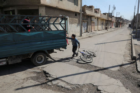 A boy plays on a street in eastern Mosul, Iraq, April 19, 2017. REUTERS/Marko Djurica