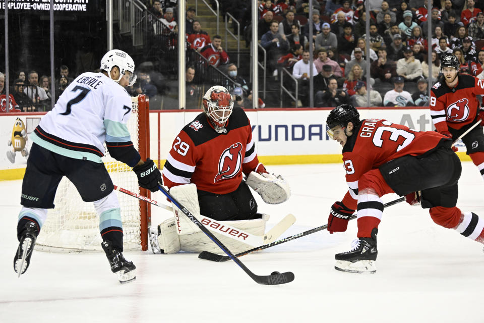 Seattle Kraken right wing Jordan Eberle (7) shoots against New Jersey Devils goaltender Mackenzie Blackwood (29) as Devils defenseman Ryan Graves (33) defends during the first period of an NHL hockey game Thursday, Feb. 9, 2023, in Newark, N.J. (AP Photo/Bill Kostroun)