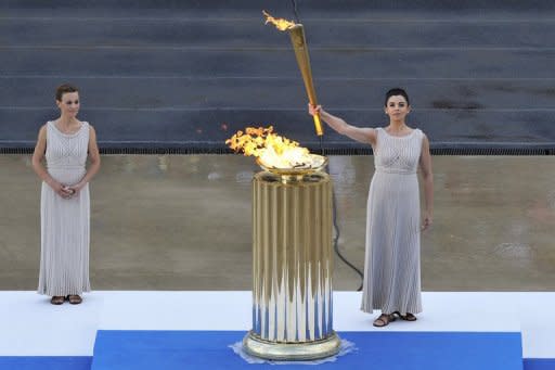 An actress at the role of the high priestess holds the Olympic torch during a ceremony for the 2012 London Olympics in Athens, May 2012. Eight years after hosting the Olympic Games in the country where they were born, Greeks seem more interested in finding out if there will be light at the end of their dismal economic tunnel than showing concern about what is happening at the London Olympics