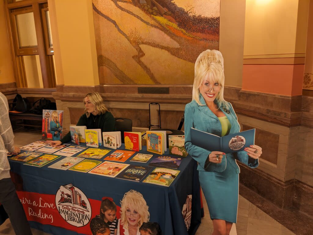 Gov. Laura Kelly signed bipartisan legislation creating a new K-12 and university program to improve reading literacy. The image is of supporters of Dolly Parton's Imagination Library hosting a table inside the Kansas Capitol. (Tim Carpenter/Kansas Reflector)