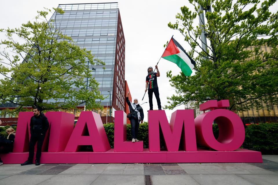 Pro-Palestinian protester waves a Palestinian flag at Hyllie arena ahead of the Eurovision contest (Andreas Hillergren)