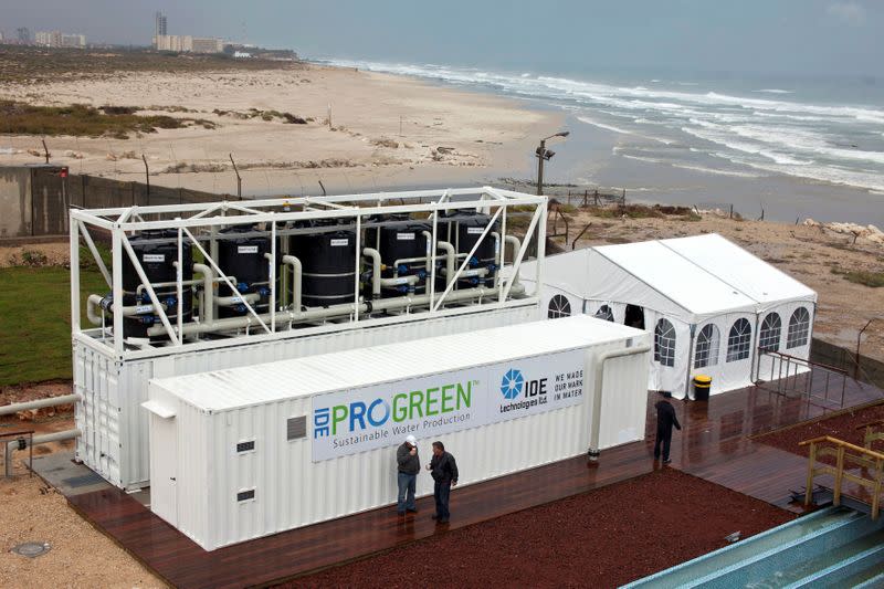 FILE PHOTO: Visitors stand near a transportable desalination system at IDE Technologies, the world's largest reverse osmosis desalination plant in Hadera