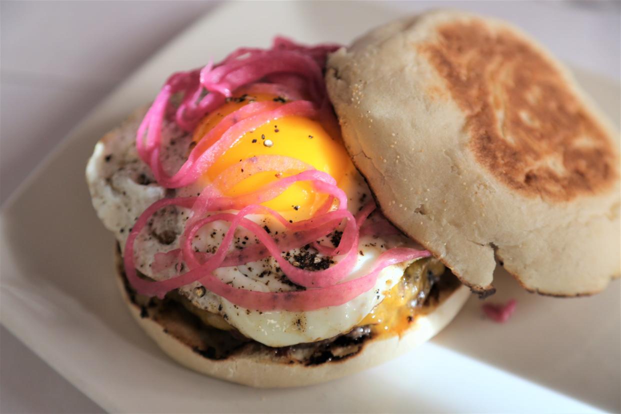 The Roast burger features a beef patty topped with bacon, cheddar, fried egg and pickled onion on English muffin.