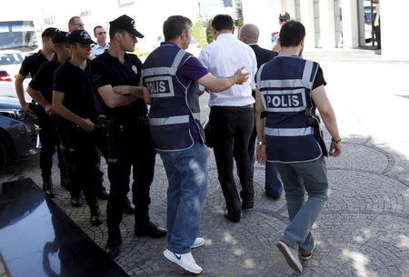 Police officers frisk an employee of the Koza Ipek Group during a raid at the company's office in Ankara, Turkey, September 1, 2015. Turkish police raided the offices of the conglomerate with close links to U.S.-based Muslim cleric Fethullah Gulen, an ally-turned-foe of President Tayyip Erdogan, company officials said on Tuesday. REUTERS/Umit Bektas