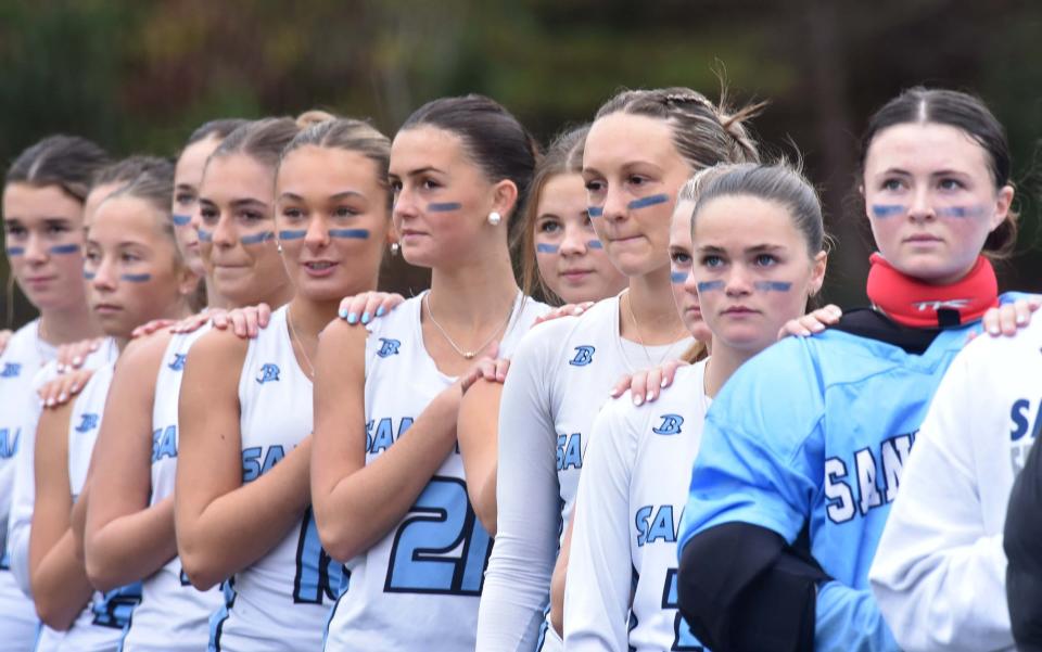 Sandwich goalie Avery Cobban, right, pauses with her teammates for the National Anthem as Sandwich hosted Foxborough in tournament field hockey action on Friday afternoon, winning the game in overtime 2-1.