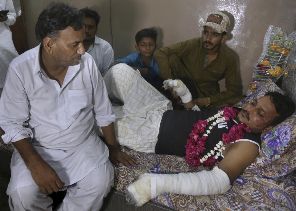 Relatives visit with Mohammad Zubair, a passenger who survived a plane crash, at his home in Karachi, Pakistan, Saturday, May 23, 2020. When the plane jolted violently, Zubair thought it was turbulence. Then the pilot came on the intercom to warn that the landing could be "troublesome." Moments later, the Pakistan International Airlines flight crashed into a crowded neighborhood near Karachi's international airport. (AP Photo/Fareed Khan)