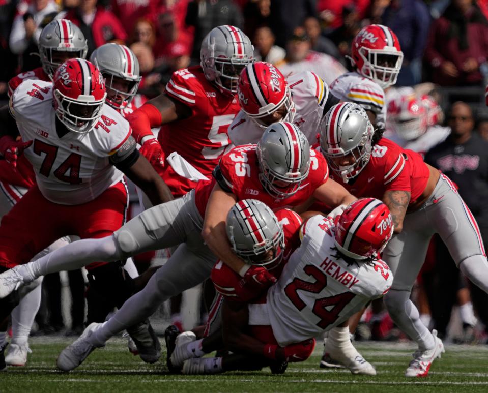 Oct. 7, 2023; Columbus, Oh., USA; 
Maryland Terrapins running back Roman Hemby (24) is tackled by Ohio State Buckeyes linebacker Tommy Eichenberg (35) and Ohio State Buckeyes safety Lathan Ransom (8) during the first half of Saturday's NCAA Division I football game at Ohio Stadium.