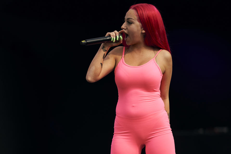 Bregoli in a hot pink unitard with bright pink hair holds a microphone close to her face in front of a black background (Cooper Neill / Getty Images)