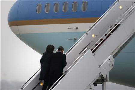 U.S. President Barack Obama and first lady Michelle Obama board Air Force One to depart for South Africa to attend memorial services for former South African President Nelson Mandela, from Joint Base Andrews, Maryland, December 9, 2013. REUTERS/Jonathan Ernst