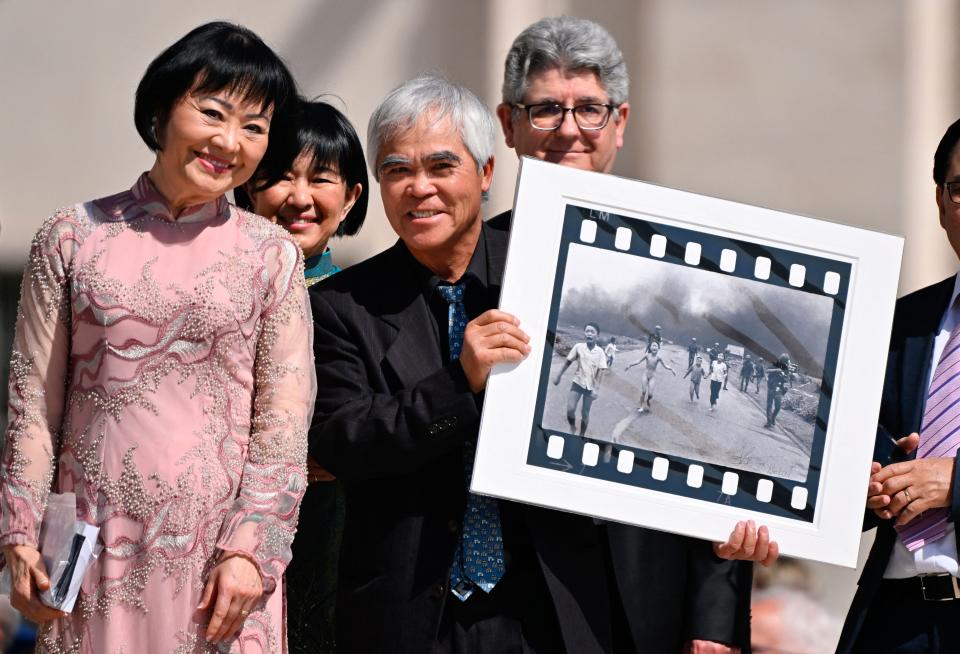 Photographer Nick Ut holds his 1972 photograph alongside Kim Phuc as they attend Pope Francis' weekly open-air general audience in St.Peters' square on May 11, 2022 at the Vatican.