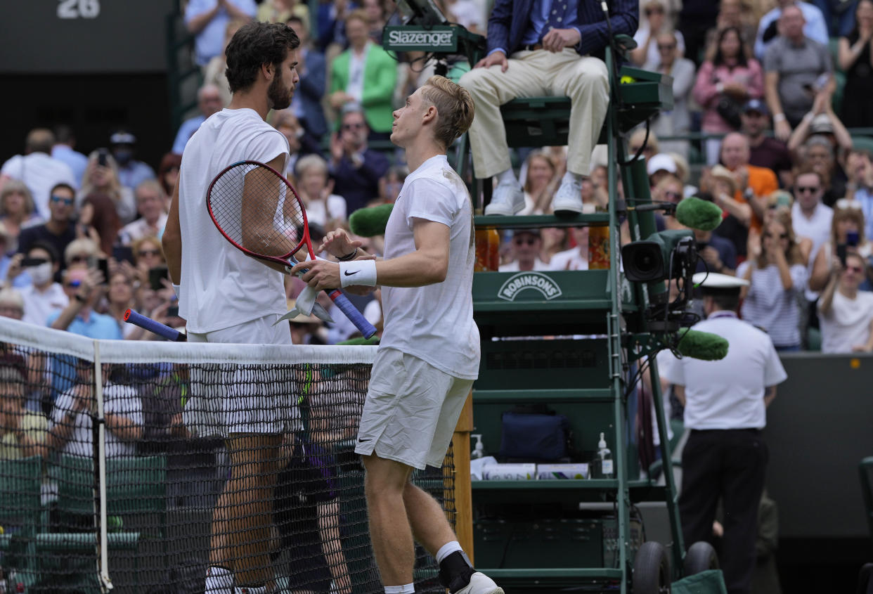 Canada's Denis Shapovalov, right, greets Russia's Karen Khachanov at the end of the men's singles quarterfinals match on day nine of the Wimbledon Tennis Championships in London, Wednesday, July 7, 2021. (AP Photo/Alastair Grant)