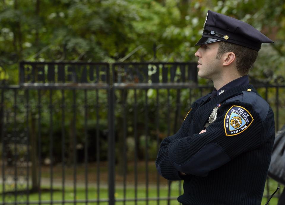 A police officer guards the entrance to Bellevue Hospital on October 24, 2014 in New York, the morning after it was confirmed that Craig Spencer, a member of Doctors Without Borders, who recently returned to New York from West Africa tested positive for Ebola.