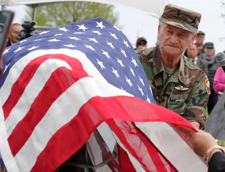 FILE - Capt Cha Yeng Lee unveils a new memorial panel during Memorial Day at the Lao, Hmong and American Veterans Memorial, Monday, May 27, 2019, in Sheboygan, Wis.