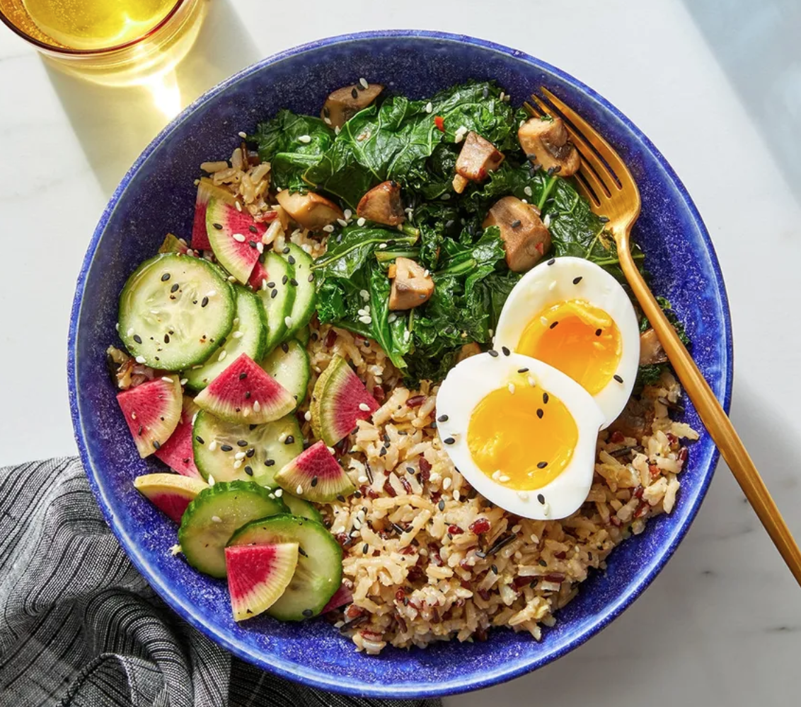 a meal bowl with eggs, rice, and greens