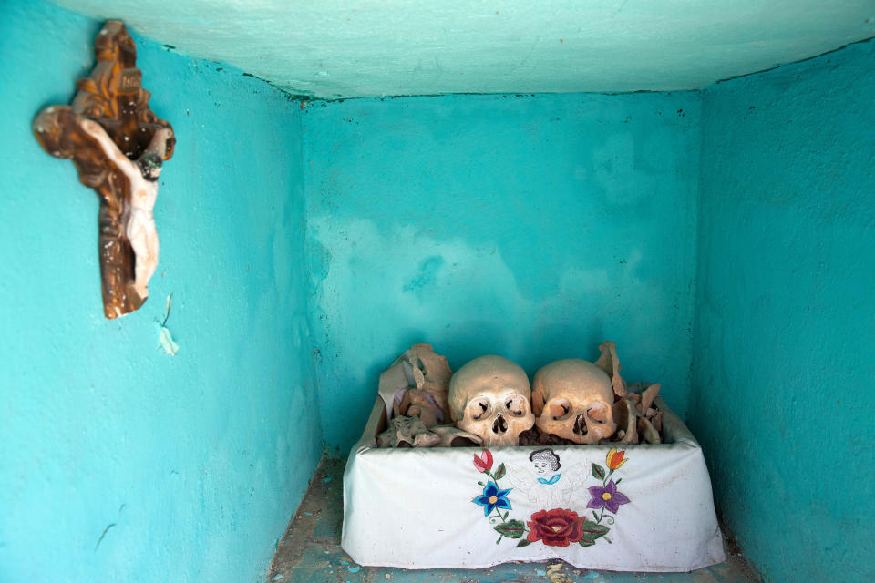 Dried-up skulls and bones are seen wrapped in embroidered white tablecloths bearing the names of the deceased, and placed in wooden crates inside a niche at the cemetery in Pomuch on Oct. 22, 2022.