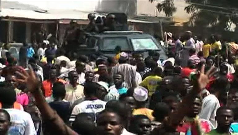 A screen grab taken from a video released by TVC News shows police forces patrolling while residents react after more than 45 people were killed in a twin bomb blasts in a market in the northeast Nigerian city of Maiduguri on November 25, 2014