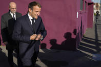 French President Emmanuel Macron, followed by French Education Minister Jean-Michel Blanquer arrive in Tremblay-en-France, outside Paris, Thursday, Oct.14, 2021. French President Emmanuel Macron will promote sports ahead of the 2024 Olympic Games in Paris. (AP Photo/Francois Mori, Pool)