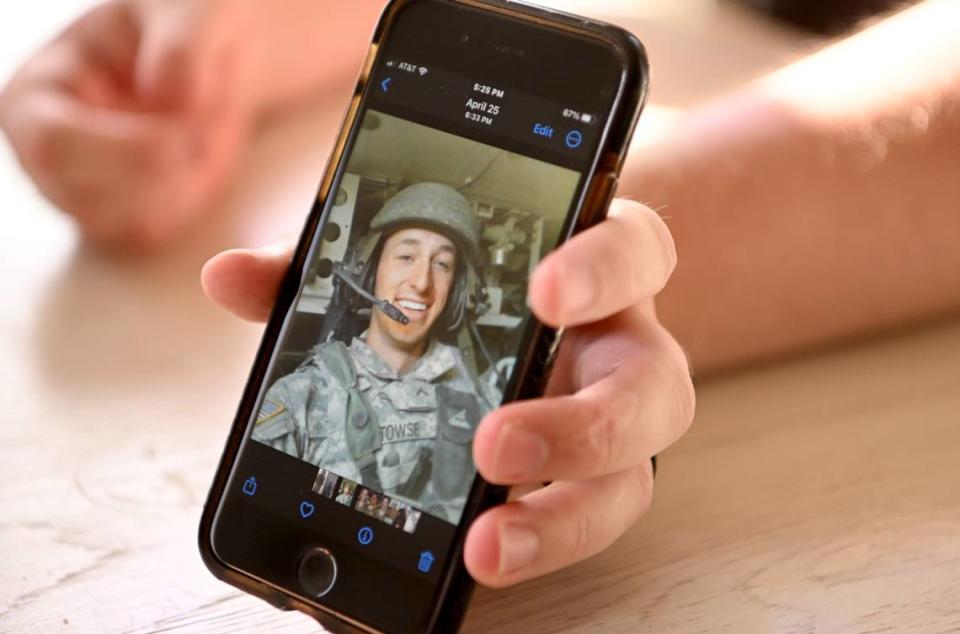 Adam Hartswick shows a photo of SPC Cody Towse as he shares a story about him on Thursday, May 11, 2023. Towse was killed in Kandahar, Afghanistan on May 14, 2013.