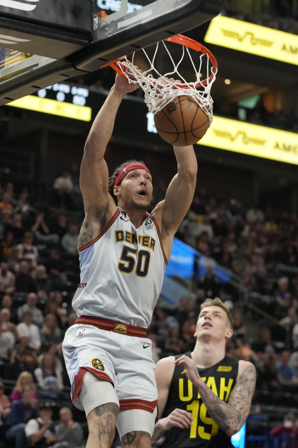 Denver Nuggets forward Aaron Gordon (50) dunks the ball as Utah Jazz forward Luka Samanic (19) looks on during the first half of an NBA basketball game Saturday, April 8, 2023, in Salt Lake City. (AP Photo/Rick Bowmer)