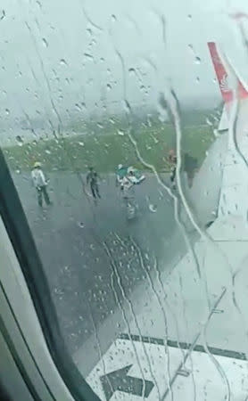 Emergency officials are seen outside of the plane in Pontianak, Kalimantan, Indonesia February 16, 2019 in this still image taken from a video obtained from social media. ANGELA MERICI PAULIN FELITA/via REUTERS