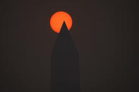 The sun rises behind the Washington Monument and a thick layer of smoke, Thursday, June 8, 2023, in Washington. Intense Canadian wildfires are blanketing the northeastern U.S. in a dystopian haze, turning the air acrid, the sky yellowish gray and prompting warnings for vulnerable populations to stay inside. (AP Photo/Julio Cortez)