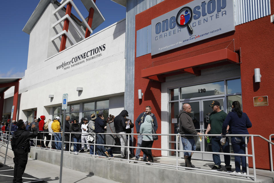 ARCHIVO - En esta fotografía del 17 de marzo de 2020, unas personas esperan en una fila para recibir ayuda con sus subsidios por desempleo en el One-Stop Career Center, en Las Vegas. (AP Foto/John Locher, Archivo)