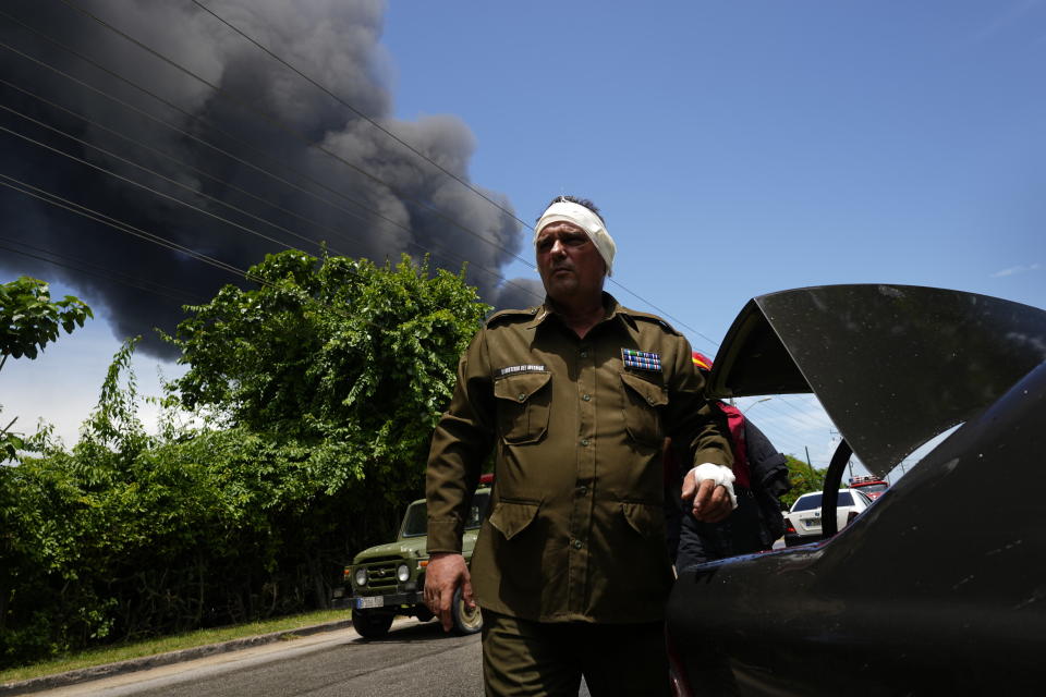 A member of the Interior Ministry injured while trying to help in rescue efforts returns to help, near the Matanzas Supertanker Base, where firefighters work to quell a blaze which began during a thunderstorm the night before, in Matazanas, Cuba, Saturday, Aug. 6, 2022. The fire at an oil storage facility raged uncontrolled Saturday, where four explosions and flames injured nearly 80 people and left over a dozen firefighters missing, Cuban authorities said. (AP Photo/Ramon Espinosa)