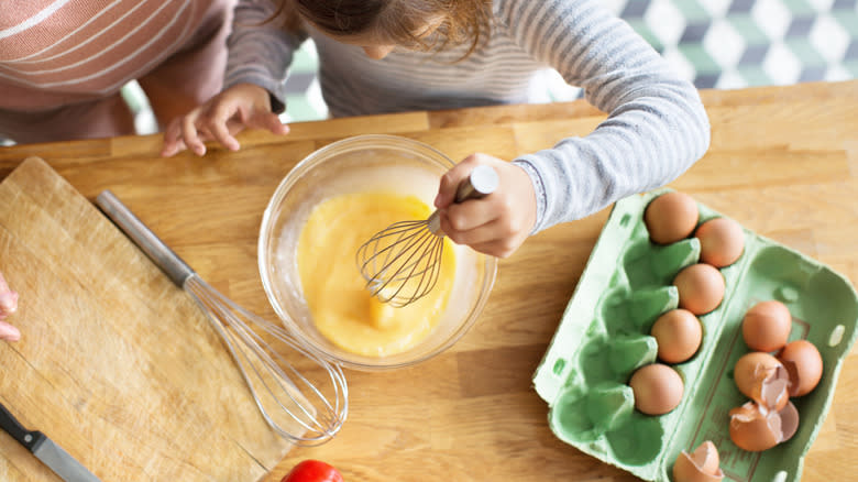 girl whisking eggs in bowl