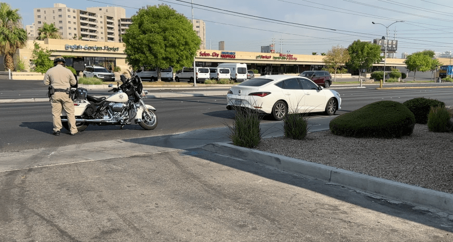 A Metro police officer cites a driver for speeding near Flamingo Road and Maryland Parkway on Friday morning. (KLAS)