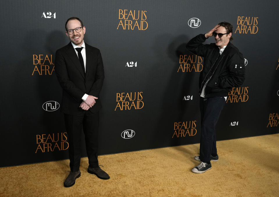 Ari Aster, left, writer/director of "Beau Is Afraid," poses for photographers as the film's star, Joaquin Phoenix, looks on at the premiere of the film, Monday, April 10, 2023, at the Directors Guild of America in Los Angeles. (AP Photo/Chris Pizzello)
