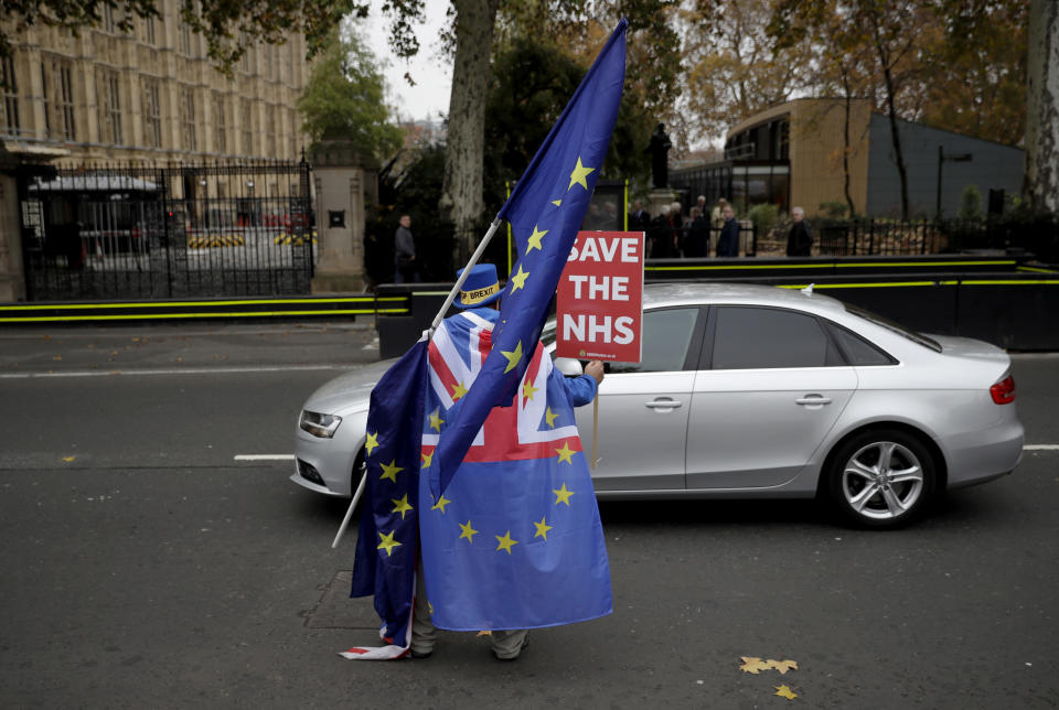 Anti-Brexit supporter Steve Bray from south Wales, runs after a car carrying former UK Independence Party leader Nigel Farage outside the Houses of Parliament in London, Thursday Nov. 15, 2018. Two British Cabinet ministers, including Brexit Secretary Dominic Raab, resigned Thursday in opposition to the divorce deal struck by Prime Minister Theresa May with the EU — a major blow to her authority and her ability to get the deal through Parliament. the Houses of Parliament in London, Thursday, Nov. 15, 2018.(AP Photo/Matt Dunham)