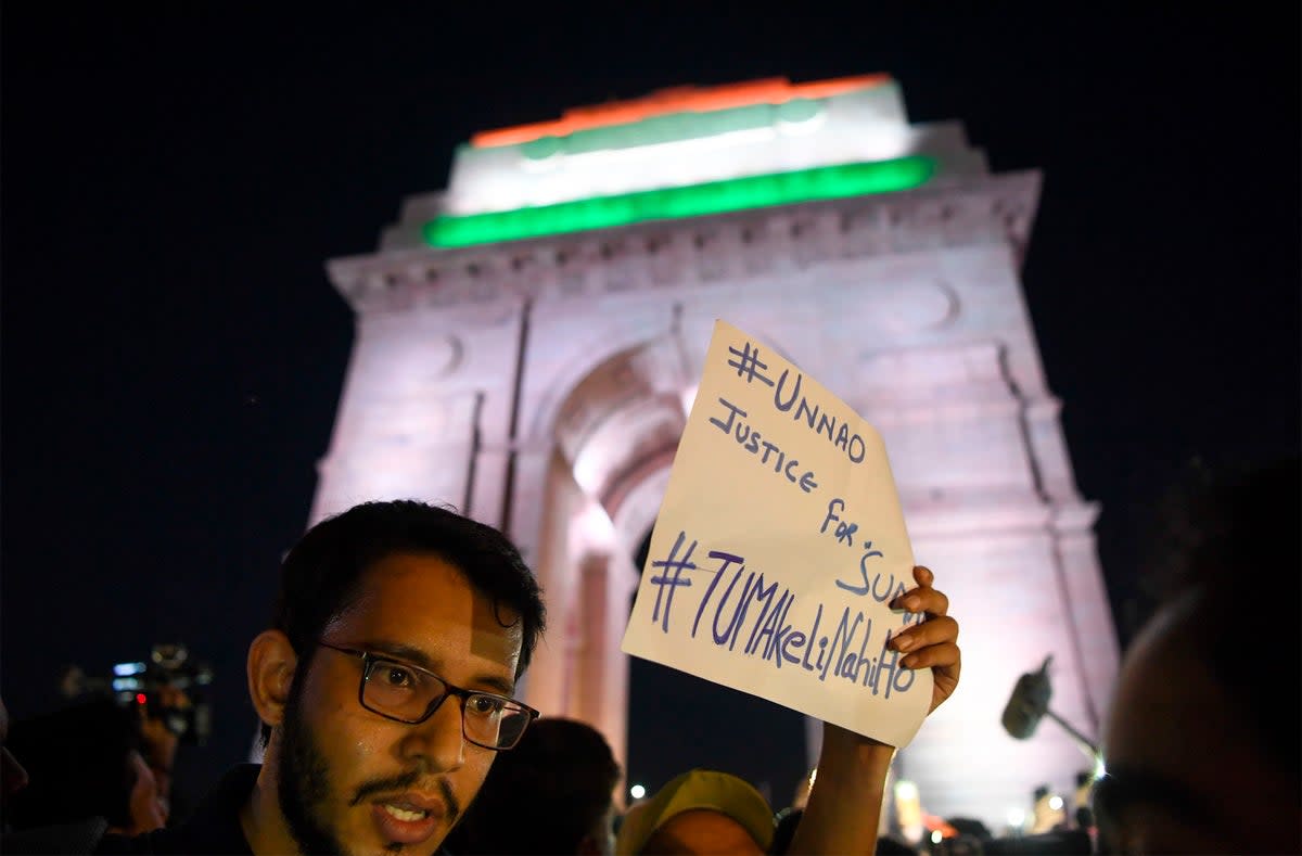 File photo: Indian social activists uses their mobile light as they take part in a solidarity rally protesting over a rape case in Unnao in front of India Gate monument in 2019  (AFP via Getty Images)