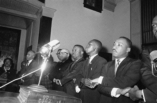 Dr. Martin Luther King, Jr., joins hands with other African American  leaders while singing "we shall over come" at a church rally in Selma, Alabama on March 9, 1965. He is expected to lead a demonstration march. From left are James Farmer, Rev. Fred Shuttlesworth, unidentified, King, Rev. Ralph Abernathy, Rev. James Bevel. (AP Photo)