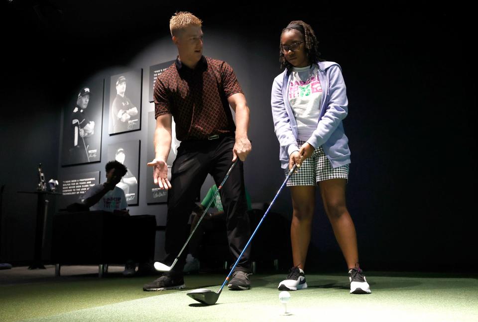 Mark Lahnala, 32, of South Lyon, left, who is a fitting specialist at PXG (Parsons Extreme Golf) in Troy, works with Lorelei Phiri, a ninth grader at Cranbrook Schools, during the one-day DAPCEP camp on July 27, 2022. Nineteen students from the metro Detroit school learned the science and engineering of golf from the clubs to ball striking.