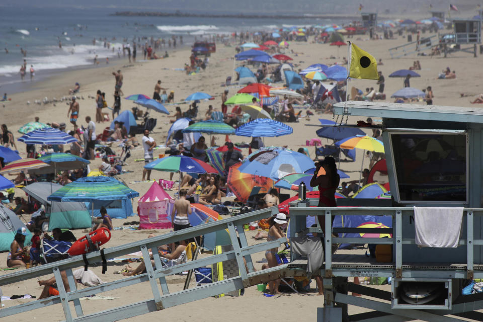 FILE - In this July 8, 2017 file photo a lifeguard scans a crowded shoreline at Manhattan Beach, Calif. California's population has stalled at 39 million people. An estimate released Friday, Dec. 20, 2019, showed the state had 39.96 million people as of July 1. (AP Photo/John Antczak,File)