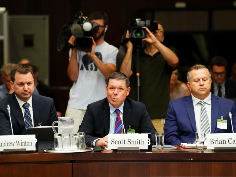 Lawyer Andrew Winton sits alongside witnesses Scott Smith, Hockey Canada president and chief operating officer and Hockey Canada chief financial officer Brian Cairo, as they appear last month at heritage committee probing the organization's handling of sexual assault allegations. (The Canadian Press - image credit)