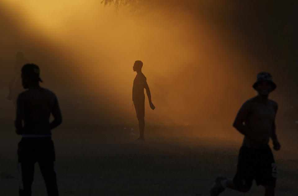 Migrants, many from Haiti, play soccer at an improvised refugee camp in Ciudad Acuña, Mexico, Wednesday, Sept. 22, 2021. (AP Photo/Fernando Llano)