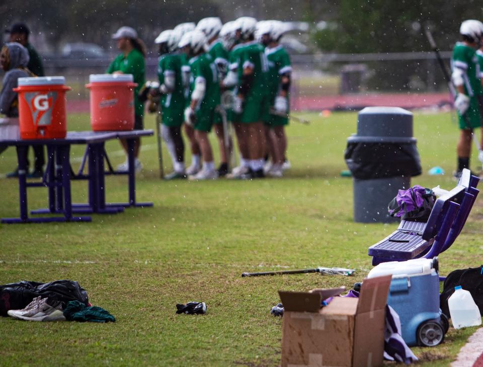 The Cypress Lake High School lacrosse bench sits empty during a recent match against Fort Myers High School. During this match, the team had just enough players to field a team. In the background are the Fort Myers substitute players.