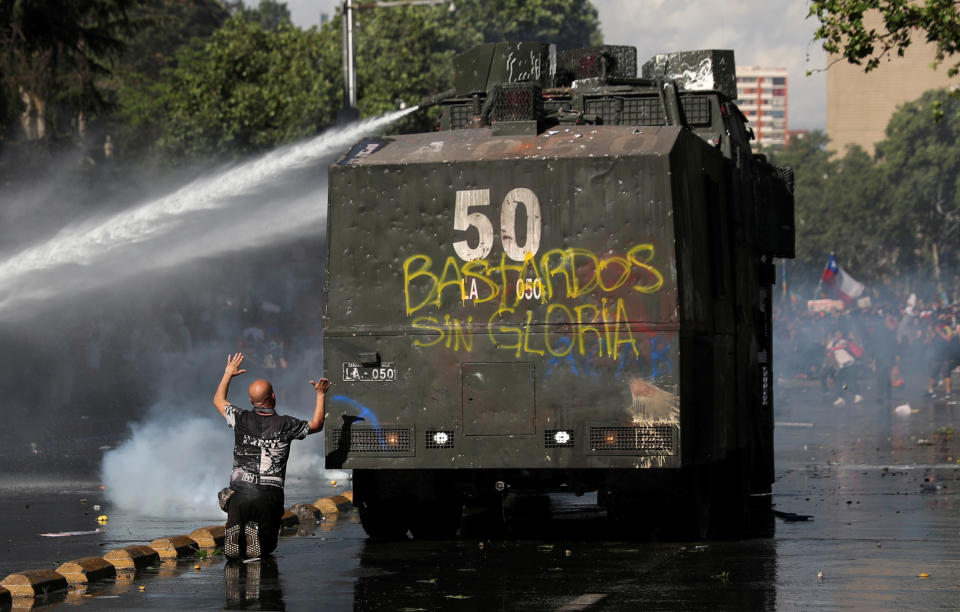 Demonstrators are sprayed by riot police with a water cannon during an anti-government protests in Santiago, Chile on Oct. 28, 2019. (Photo: Edgard Garrido/Reuters)