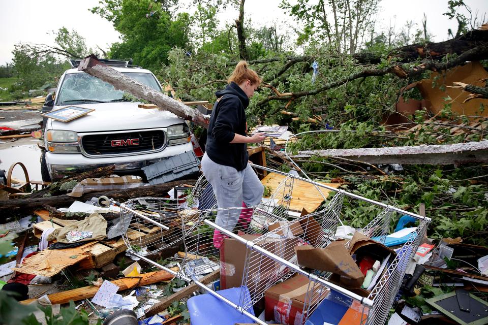 Michelle Underwood searches through the wreckage of a feed store where she stored most of her belongings in Peggs, Okla., Tuesday, May 21, 2019.