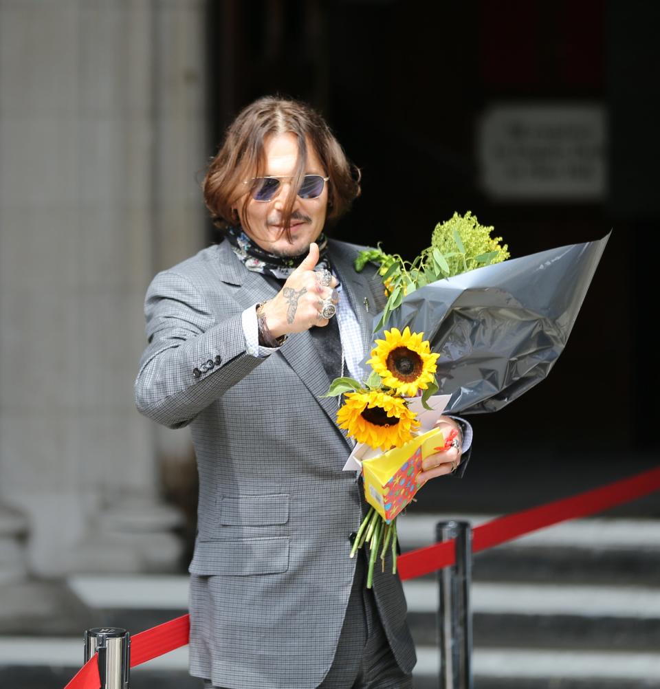 deep holding a bouquet of flowers and giving a thumbs up