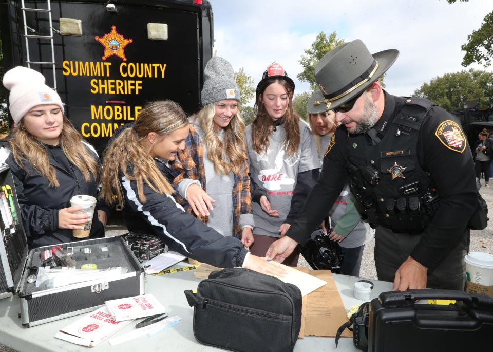 Sheriff Deputy Brian Gorham works with Green High School students at a crime scene unit activity at the Faith & Blue event on Saturday.