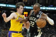 Milwaukee Bucks' Khris Middleton tries to get past Los Angeles Lakers' Austin Reaves during the second half of an NBA basketball game Tuesday, March 26, 2024, in Milwaukee. The Lakers won 128-124 in double overtime. (AP Photo/Morry Gash)