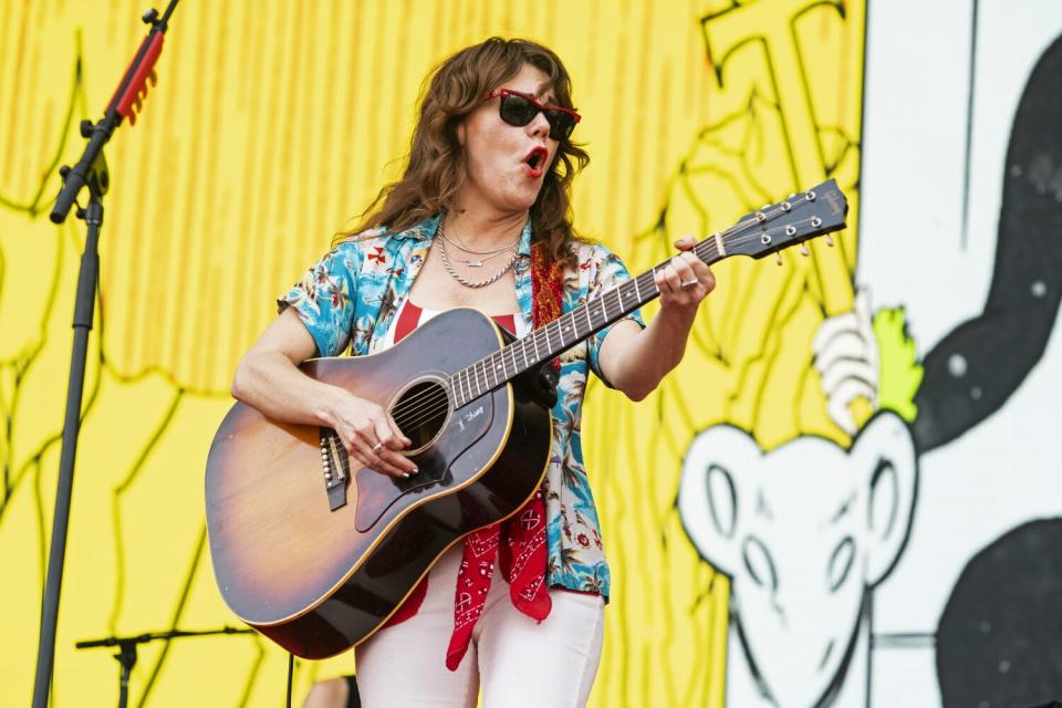 A female singer-guitarist performs onstage