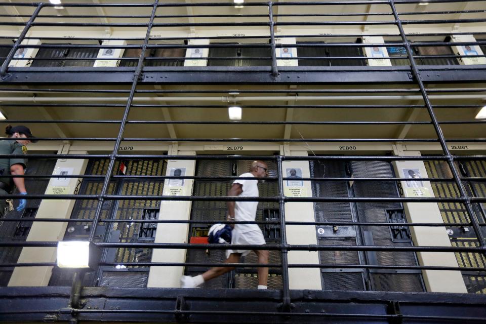 In this Aug. 16, 2016 file photo, a condemned inmate walks along the east block of death row at San Quentin State Prison in San Quentin, Calif. Gov. Gavin Newsom is expected to sign a moratorium on the death penalty in California Wednesday, March 13, 2019. (AP Photo/Eric Risberg, File)
