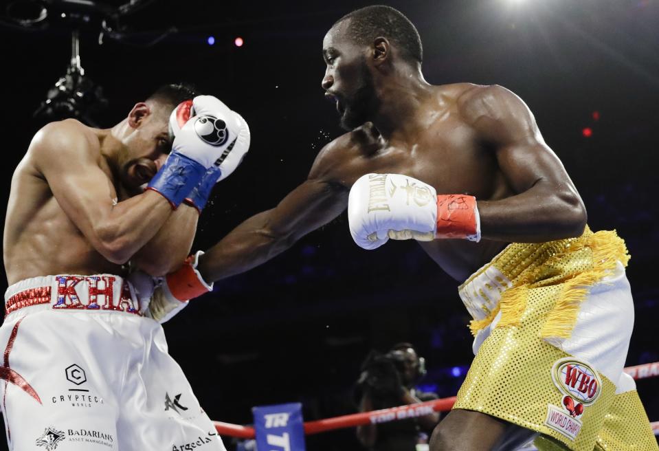 Terence Crawford, left, punches England's Amir Khan during the fourth round of a WBO world welterweight championship boxing match Sunday, April 21, 2019, in New York. Crawford won the fight. (AP Photo/Frank Franklin II)