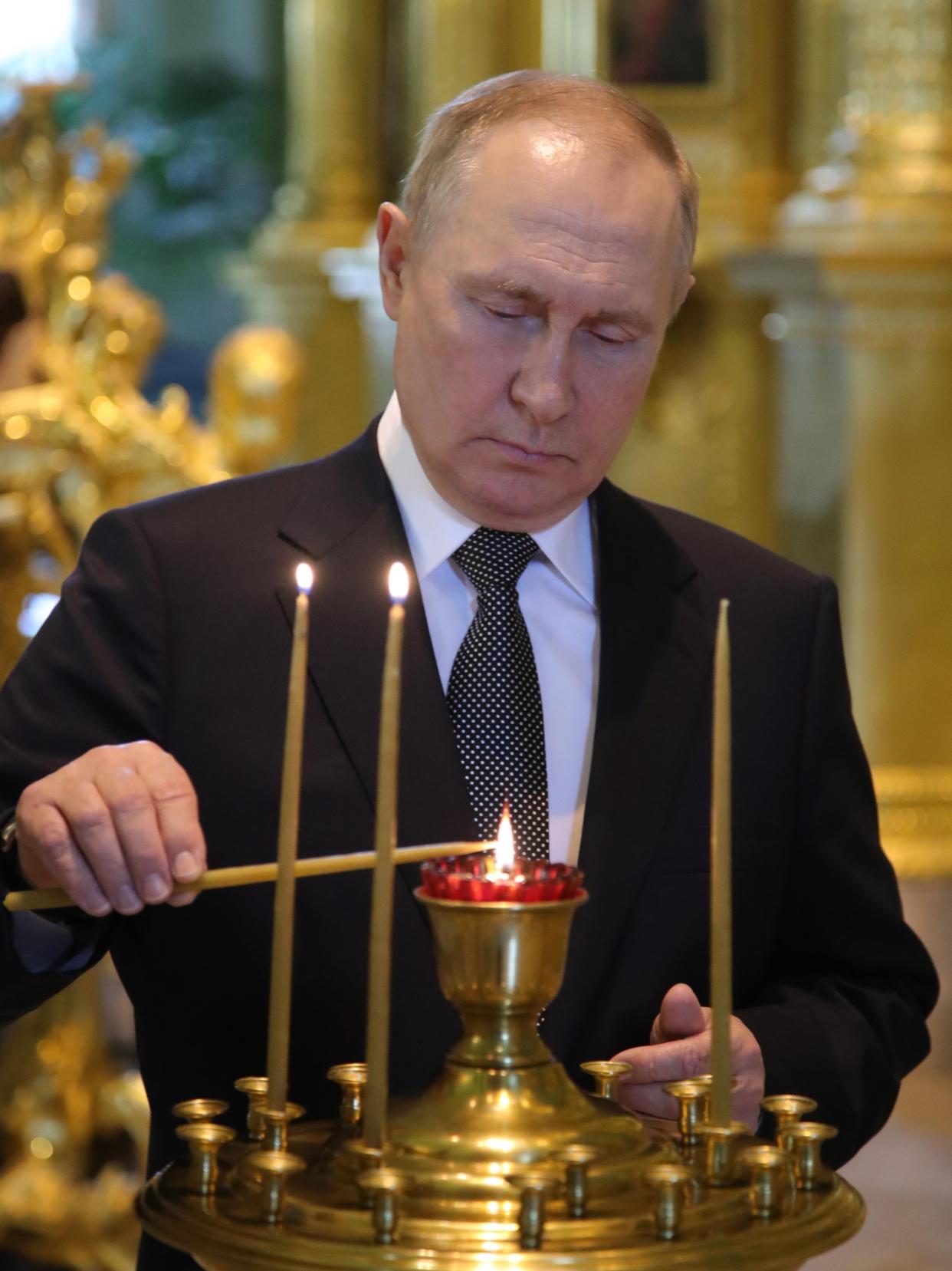 FILE - Russian President Vladimir Putin lights a candle visiting the Peter and Paul Cathedral prior to signing the decrees approving the Naval Doctrine and the Ship Charter of the Russian Navy in the St. Petersburg State History Museum and before the main naval parade marking Russian Navy Day in St. Petersburg, Russia, Sunday, July 31, 2022. Putin, who turned 70 on Friday, has found himself increasingly cornered with his army suffering humiliating defeats in Ukraine, hundreds of thousands of Russians fleeing his mobilization order and rifts opening up among his top lieutenants. (Mikhail Klimentyev, Sputnik, Kremlin Pool Photo via AP, File)