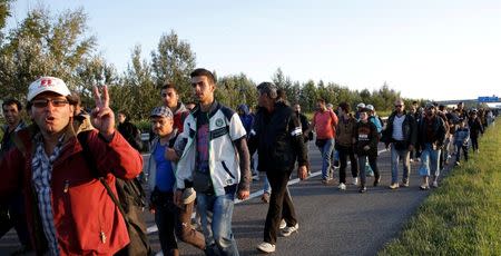 A group of migrants walks against the traffic on a motorway leading to Budapest as they left a transit camp in the village of Roszke, Hungary, September 7, 2015. REUTERS/Marko Djurica