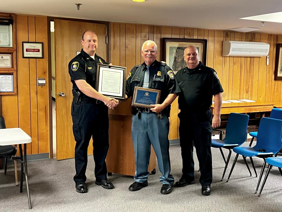 Mackinaw City Police Chief Todd Woods (left) and Alpena City Police Chief Joel Jett (right), both representing the Northern Michigan Association of Chiefs of Police, presented Cheboygan City Police Chief Kurt Jones with a certificate of appreciation and a plaque thanking him for his many years of service to the community at the city council meeting Aug. 9.