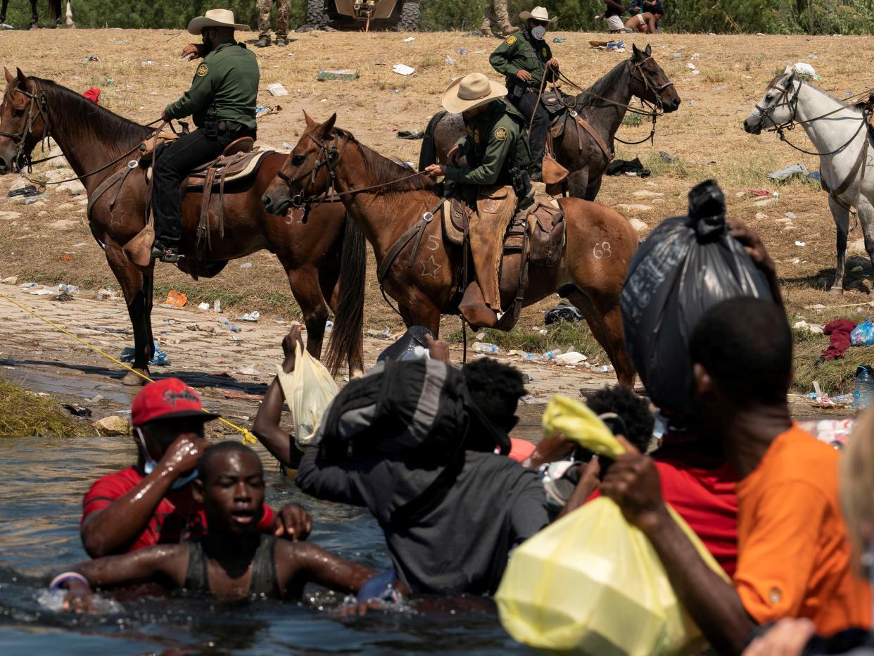 Border patrol agents and asylum seeking migrants at the US-Mexico border (REUTERS)